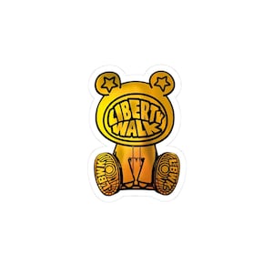 May include: A gold sticker in the shape of a bear with the words "LIBERTY WALK" in a black, bold font. The bear has star-shaped ears and "LBWK" printed on its feet.