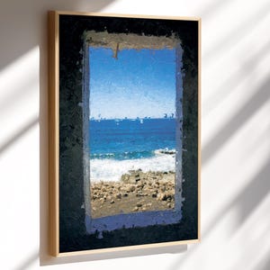 May include: A framed art print depicting a coastal scene. The artwork features a view of the ocean through a window, with blue water, white waves, and a rocky shore. The frame is a light wood color, and the artwork is mounted on a white wall.