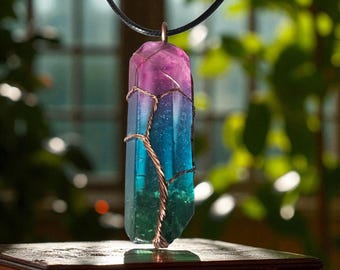May include: A colorful crystal pendant with a gradient of purple, blue, and green hues. The crystal is wrapped in copper wire and hangs from a black cord. The pendant is displayed on a wooden surface.