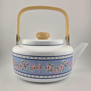 Bouilloire vintage en émail blanc, poignée supérieure en bois et bouton de couvercle, décorée de roses pivoines roses sur une bannière bleu pâle et bleu foncé, 1980s