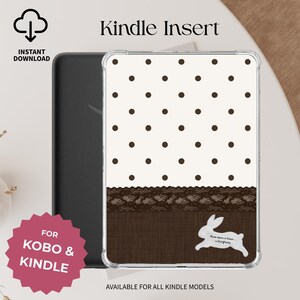 May include: A clear e-reader case insert featuring a white top section with brown polka dots, a dark brown lace trim, and a solid dark brown bottom section. A white rabbit silhouette is printed with the text Once upon a time... a fairytale.