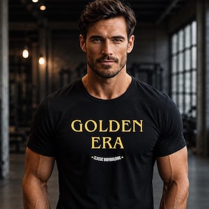Könnte beinhalten: Ein schwarzes Kurzarm-T-Shirt mit dem Text GOLDEN ERA in goldener Schrift auf der Brust und dem kleineren Text CLASSIC BODYBUILDING direkt darunter. Das T-Shirt hat einen Rundhalsausschnitt und eine normale Passform.