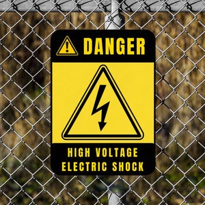 May include: A warning sign with the word "DANGER" and "HIGH VOLTAGE ELECTRIC SHOCK" in black text on a yellow and black background. The sign shows a lightning bolt symbol. It is attached to a chain-link fence.