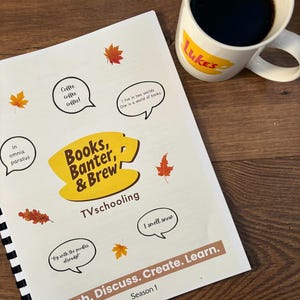 Peut inclure: Un livre à spirales intitulé "Books, Banter, & Brew" avec le texte "Watch. Discuss. Create. Learn. Season 1." Une tasse blanche avec le mot "Luke's" et remplie de café est posée à côté du livre. Des feuilles d'automne décoratives sont éparpillées.