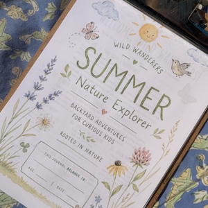 May include: A printed activity sheet on a clipboard titled Summer Nature Explorer, featuring watercolor illustrations of a sun, butterfly, bird, and wildflowers. The text reads Wild Wanderers, Backyard Adventures For Curious Kids, and Rooted In Nature, with a section for name, age, and date.