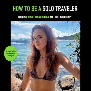May include: A woman in a snake-print bikini stands by the sea. The image includes the text "HOW TO BE A SOLO TRAVELER" and "THINGS I WISH I KNEW BEFORE MY FIRST SOLO TRIP." A green badge says "Unlock a life of freedom and joy."