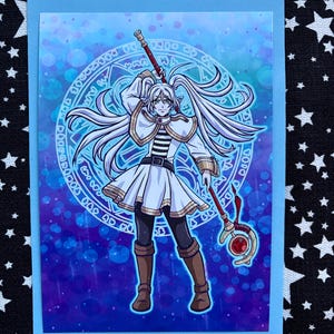 May include: A fantasy art print depicting a character with long white hair, dressed in white and gold attire, holding a staff with a red gem. The background is a blue and purple gradient with a magical circle design.