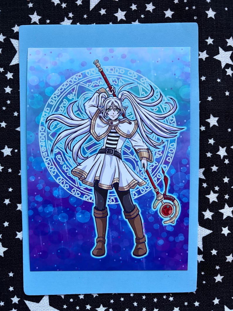 May include: A fantasy art print depicting a character with long white hair, dressed in white and gold attire, holding a staff with a red gem. The background is a blue and purple gradient with a magical circle design.