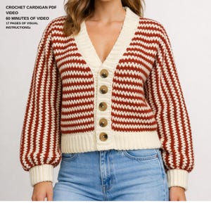 May include: A cream-colored, V-neck cardigan with horizontal red stripes and six brown buttons. The long-sleeved sweater has a ribbed hem and cuffs. The text "CROCHET CARDIGAN PDF VIDEO 60 MINUTES OF VIDEO 17 PAGES OF VISUAL INSTRUCTIONSz" is visible.