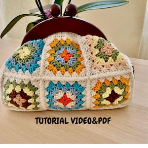 Könnte beinhalten: Eine cremefarbene Häkeltasche mit einem farbenfrohen Granny-Square-Design. Die Quadrate weisen verschiedene Farben auf, darunter Blau, Orange, Gelb und Grün. Der Text "TUTORIAL VIDEO&PDF" ist unten auf der Tasche zu sehen.