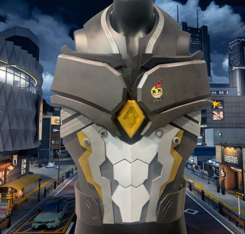 May include: A futuristic-style chest armor in shades of gray, white, and yellow, displayed on a mannequin. The armor features a yellow diamond-shaped accent and a small emblem with a smiling face. The background shows a cityscape.