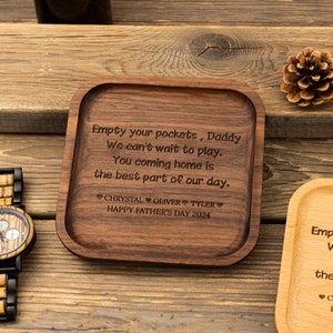 May include: A wooden tray with a personalized message: "Empty your pockets, Daddy We can't wait to play. You coming home is the best part of our day."  The tray is engraved with the names "CHRYSTAL OLIVER TYLER" and the date "HAPPY FATHER'S DAY 2024".
