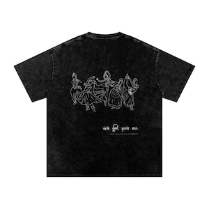 May include: Black t-shirt with a white line drawing of dancing figures. The shirt has a vintage wash appearance. Below the figures is text in a foreign language, with the English translation "where the mind goes, the road follows."