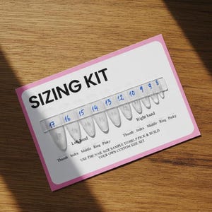 以下が含まれることがあります： 「SIZING KIT」の文字が入ったピンクと白のネイルサイジングキット。キットには、左手と右手にラベル付けされた、番号8〜17の透明なプラスチック製のネイルサンプルが含まれています。