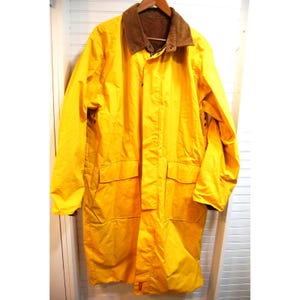 May include: A bright yellow raincoat with a brown corduroy collar. The long coat has two large front pockets and a button closure. The coat is hanging on a wooden hanger against a white background.