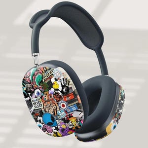 以下が含まれることがあります： ステッカーで覆われたイヤーカップデザインの濃い灰色のオーバーイヤーヘッドフォン。ステッカーには、エイリアン、目、「Gamers Never Sleep」のテキストなど、さまざまなカラフルなグラフィックが使用されています。ヘッドバンドも濃い灰色です。