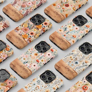 Puede incluir: Una colección de fundas para teléfonos con diseños florales y detalles de madera. Cada funda presenta un diseño floral único en varios colores, con un panel de madera en la parte inferior. Los nombres están grabados en los paneles de madera.