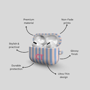 Puede incluir: Una funda para AirPods Pro a rayas azules y rosas con las iniciales "CT" en rosa. La funda est&aacute; abierta, revelando unos AirPods blancos. La imagen destaca las caracter&iacute;sticas de la funda: material de primera calidad, estampados que no se decoloran, acabado brillante, protecci&oacute;n duradera y dise&ntilde;o ultra delgado.