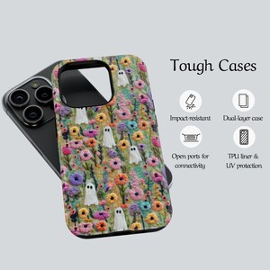 May include: A phone case with a colorful floral design and white ghost figures. The case is on a black phone. The text "Tough Cases" is displayed. Features include impact resistance, dual-layer case, open ports, and UV protection.