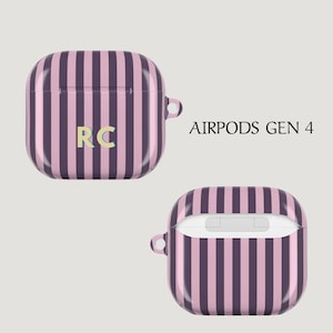 Puede incluir: Funda AirPods Gen 4 a rayas rosas y moradas. La funda tiene una carcasa dura con un acabado brillante y un peque&ntilde;o lazo para sujetarla a un llavero. Las iniciales "RC" est&aacute;n en el centro de la funda.