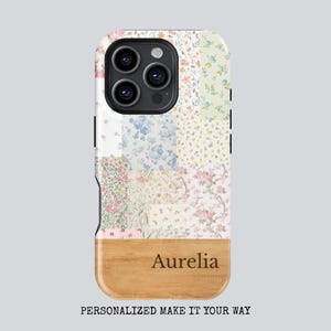 Op de afbeelding: Een telefoonhoesje met bloemenpatchwork en een houten onderkant. De hoes heeft verschillende bloempatronen in roze, blauw en geel. De naam "Aurelia" staat op het houten gedeelte. De tekst "GEPERSONALISEERD MAAK HET JOUW MANIER" staat onderaan.