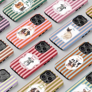 Op de afbeelding: Een verzameling telefoonhoesjes met kleurrijke gestreepte achtergronden. Elk hoesje heeft een aquarel illustratie van een hond of kat in een ovale lijst. De hoesjes zijn in verschillende kleuren, waaronder roze, oranje en groen.
