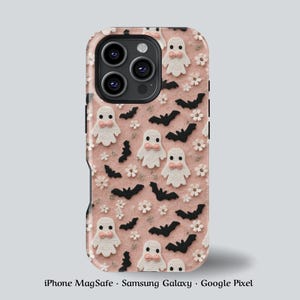 以下が含まれることがあります： ハロウィーンをテーマにした携帯電話ケース。ピンクの背景に、ピンクのリボンが付いた白いお化け、黒いコウモリ、小さな白い花がパターン化されています。iPhone MagSafe、Samsung Galaxy、Google Pixelに対応しています。
