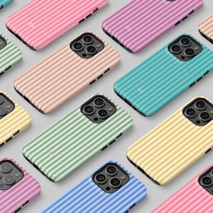 Puede incluir: Una colección de fundas de teléfono coloridas con un patrón de rayas. Las fundas son de varios colores, incluyendo rosa, morado, azul, verde y amarillo. Cada funda tiene una inicial diferente.