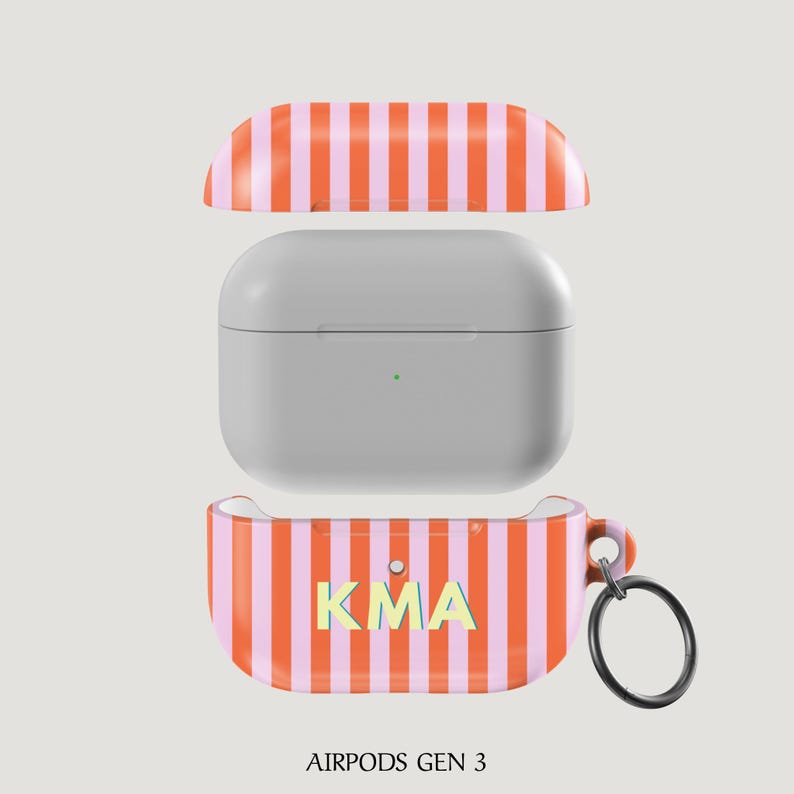 Puede incluir: Funda para AirPods Gen 3 con dise&ntilde;o de rayas naranjas y rosas. La funda est&aacute; abierta, mostrando los AirPods grises en su interior. La parte inferior de la funda tiene las letras "KMA" en amarillo y azul claro. Un llavero negro est&aacute; adjunto.