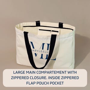 May include: A large off-white canvas tote bag with black handles and a blue logo reading MARYLEELU. The bag features a main compartment with a zippered closure and an interior zippered flap pouch pocket for secure storage of small items.