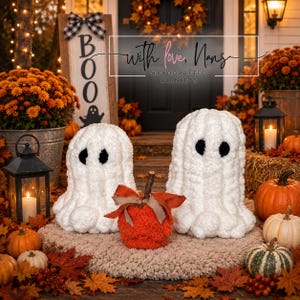 May include: Two white plush ghost figures with black felt eyes and a central orange textured pumpkin plush featuring a brown stem and a burlap ribbon bow, all arranged on a beige circular rug surrounded by various orange and green pumpkins.