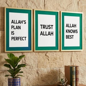 Puede incluir: Tres impresiones artísticas enmarcadas con marcos dorados y paspartús verdes. Las impresiones muestran las frases "ALLAH'S PLAN IS PERFECT", "TRUST ALLAH" y "ALLAH KNOWS BEST" en texto negro en negrita sobre un fondo blanco. Una planta en maceta y libros son visibles debajo.