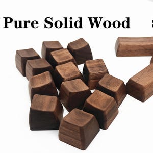 Puede incluir: Un conjunto de teclas de teclado de madera maciza de color marrón oscuro de varias formas, con el texto "Pure Solid Wood SA PROFILE" en el fondo. Las teclas están dispuestas sobre una superficie blanca.