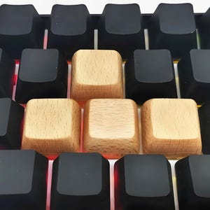 May include: Close-up of a mechanical keyboard with a mix of black and light wood keycaps. The Esc key has a logo and text. The keyboard has a red underglow.