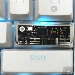 Peut inclure: Gros plan sur un clavier mécanique blanc avec rétroéclairage bleu. Les touches du clavier incluent "Enter" et "Shift" avec une touche transparente montrant le circuit imprimé interne. Le clavier est de conception moderne.