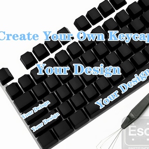 Puede incluir: Teclas de teclado negras con el texto "Create Your Own Keycaps" y "Your Design" en azul claro. Se incluye un extractor de teclas. La imagen muestra un concepto de personalización de teclado.