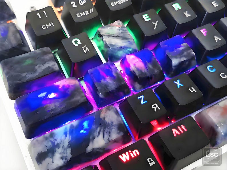 May include: Close-up of a mechanical keyboard with custom keycaps. The keycaps are black with a marbled, translucent design in shades of blue, purple, and white. The keyboard has LED backlighting in various colors, including red, green, and blue.
