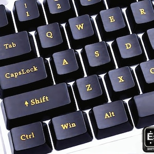May include: Close-up of a black keyboard with gold lettering. The keys include letters, numbers, and function keys like CapsLock, Shift, Ctrl, Alt, and Win. The Esc key is in the bottom right corner.