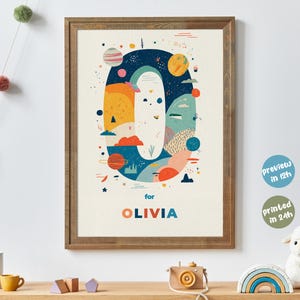 Puede incluir: Un póster enmarcado con un diseño abstracto y colorido de la letra "O" con temática espacial. El póster incluye planetas, estrellas y el nombre "OLIVIA" en naranja. El marco es de color marrón cálido.