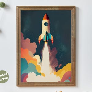 Könnte beinhalten: Gerahmter Druck einer Rakete, die abhebt, vor einem dunkelblauen Himmel mit bunten Wolken. Die Rakete ist cremefarben mit roten und türkisfarbenen Akzenten. Der Rahmen hat eine natürliche Holzfarbe. Der Text "printed in 24h" steht unten links.