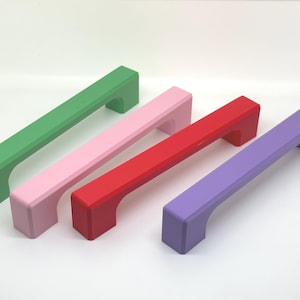 Peut inclure: Quatre poignées de meubles colorées en vert, rose, rouge et violet. Chaque poignée a une barre rectangulaire avec des poignées incurvées. Les poignées mesurent environ 15 cm de long, parfaites pour les tiroirs ou les armoires.
