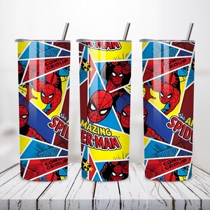 May include: Three stainless steel tumblers with Spider-Man comic book graphics. The design features Spider-Man in action poses, with text that reads "The Amazing Spider-Man" and "Comic Group". The tumblers have a straw and are set against a white wooden surface.