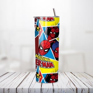May include: A tall, stainless steel tumbler featuring a vibrant design of the Amazing Spider-Man. The tumbler has a straw and a lid. The design includes Spider-Man's face and the words "Amazing Spider-Man" in a comic book style.