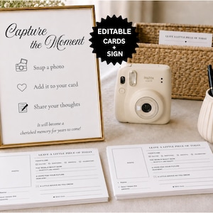 Puede incluir: Un letrero con marco dorado que dice Capture the Moment con instrucciones para tomar una foto, añadir a la tarjeta y compartir pensamientos, junto a una cámara instantánea beige, una cesta tejida, un portalápices y tarjetas blancas impresas.