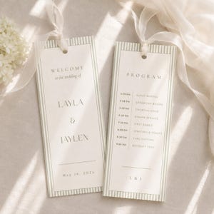 Könnte beinhalten: Zwei rechteckige Hochzeitskarten mit hellgrün gestreiften Rändern und weißen Schleifenbändern. Die linke Karte zeigt WELCOME to the wedding of LAYLA & JAYLEN May 16, 202X. Die rechte Karte listet das PROGRAM von 16:30 bis 21:00 Uhr mit L & J auf.