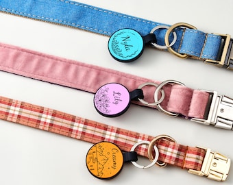 Puede incluir: Tres collares para mascotas con hebillas metálicas y placas circulares. El collar superior es de mezclilla azul con una placa turquesa con el nombre Nyla. El central es de terciopelo rosa con una placa rosa claro con el nombre Lily. El inferior es de cuadros naranjas con una placa naranja con el nombre Creamy.