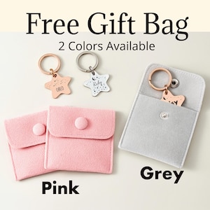Puede incluir: La imagen muestra llaveros personalizados en forma de estrella en oro rosa y plata, con nombres grabados. Tambi&eacute;n se muestran dos bolsas rosas y una gris. El texto "Free Gift Bag" y "2 Colors Available" son visibles.