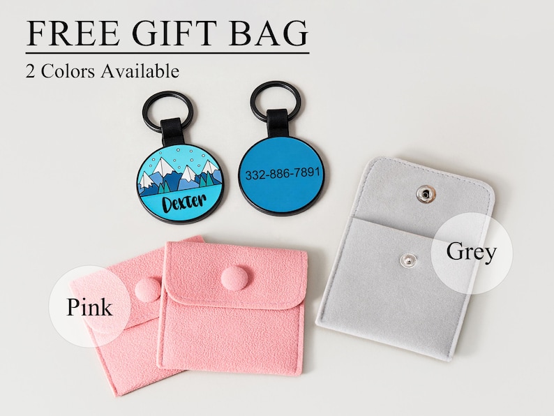 May include: Two round pet tags with black rings, one blue with a mountain design and the name "Dexter", the other blue with a phone number. Also, two pink pouches and a grey pouch with snap closures. Text reads "FREE GIFT BAG" and "2 Colours Available".