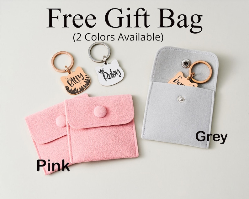 May include: A promotional image featuring cat-shaped keychains with names, presented in pink and grey pouches. The keychains are gold and silver, with the text "Billy" and "Ruby". The image includes the text "Free Gift Bag" and "(2 Colors Available)".
