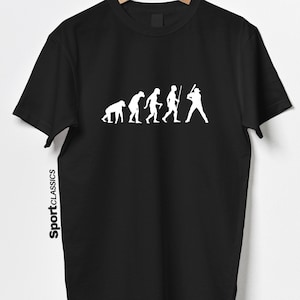 Puede incluir: Camiseta negra con un gráfico blanco que representa la evolución del béisbol. El diseño muestra una progresión de simio a jugador de béisbol. El texto "Sport Classics" está impreso verticalmente en el lado izquierdo de la camiseta.